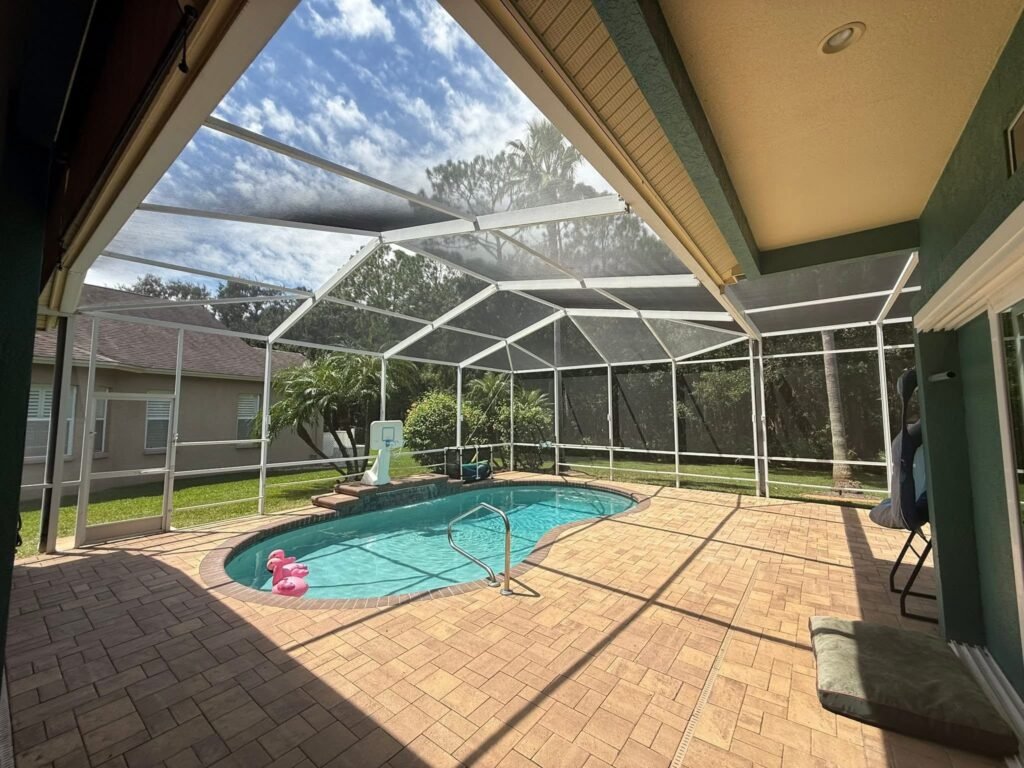 White aluminum pool enclosure installation around residential swimming pool in Clermont, FL